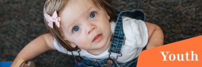 A young child looking up at the camera. 