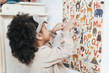 Britannica Fundamentals resource image showing a young girl pointing at a graphic poster of the alphabet