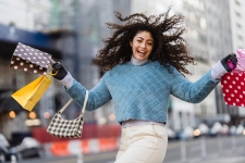 Consumer Reports (Ebsco) resource image showing a smiling woman walking down the street with several shopping bags