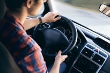 Driving-Tests.org resource image showing a male teen with hands on a steering wheel