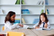 Explora for Elementary Schools resource image showing two small girls at a table flipping through books