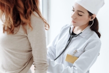 Health Source: Nursing/Academic Edition resource image showing a female doctor listening to a patient's breathing with a stethoscope