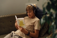 Middle & Junior High Core Collection resource image showing a middle school aged boy with headphones on reading a book