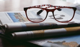 NewspaperARCHIVE (Oshkosh Area) resource image showing newspapers with a pair of reading glasses sitting on top