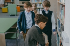 NoveList K-8 resource image showing young students looking at books on a bookshelf