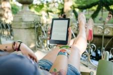 Overdrive/Libby resource image showing a woman reclined with an e-reader tablet in her hand