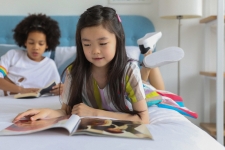 Primary Search resource image showing two girls on a bed, one flipping through a magazine and one reading a book