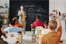 Teacher Reference Center resource image showing a teacher standing in front of a chalkboard in front of what looks to be middle school aged students