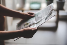 Archive of Wisconsin Newspapers resource image showing a person holding a newspaper